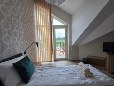 a bedroom with a bed and a large window at Stay at Royal Kraków Golf