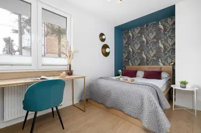 a bedroom with a bed and a desk and a chair at Modern Apartment Kraków Potrzask - AC, Terrace & Parking by Noclegi Renters in Kraków