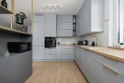 a kitchen with white cabinets and a counter top at Modern Apartment Kraków Potrzask - AC, Terrace & Parking by Noclegi Renters in Kraków
