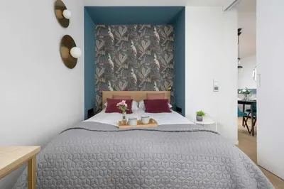 a bedroom with a bed with a blue wall at Modern Apartment Kraków Potrzask - AC, Terrace & Parking by Noclegi Renters in Kraków