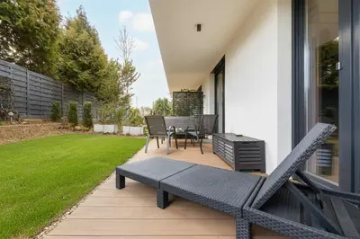 a patio with a bench and a table and chairs at Modern Apartment Kraków Potrzask - AC, Terrace & Parking by Noclegi Renters in Kraków