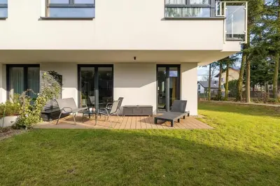 a house with a patio with chairs and a table at Modern Apartment Kraków Potrzask - AC, Terrace & Parking by Noclegi Renters in Kraków