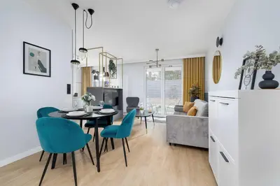 a kitchen and living room with a table and chairs at Modern Apartment Kraków Potrzask - AC, Terrace & Parking by Noclegi Renters in Kraków