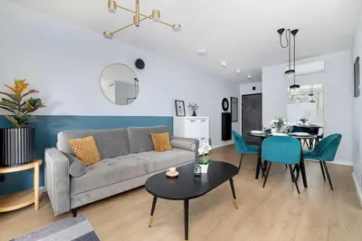 a living room with a couch and a dining room at Modern Apartment Kraków Potrzask - AC, Terrace & Parking by Noclegi Renters in Kraków