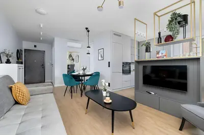 a living room with a couch a table and a tv at Modern Apartment Kraków Potrzask - AC, Terrace & Parking by Noclegi Renters in Kraków