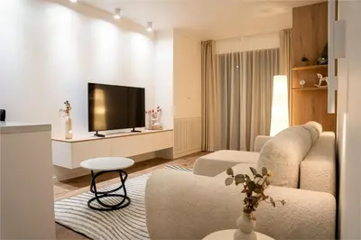 a living room with a couch and a tv at Apartament Zakrzówek - Chilloway in Kraków