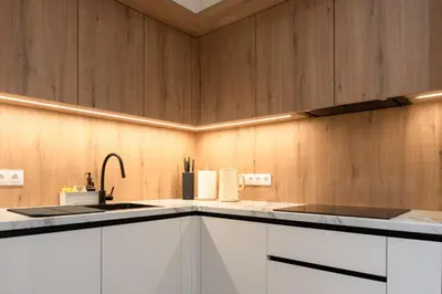 a kitchen with white cabinets and a sink at Apartament Zakrzówek - Chilloway in Kraków