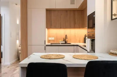 a kitchen with a table with two pizzas on it at Apartament Zakrzówek - Chilloway in Kraków