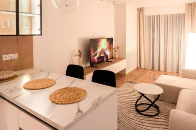 a kitchen and living room with a table and chairs at Apartament Zakrzówek - Chilloway in Kraków