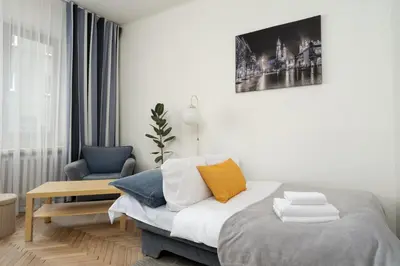 a bedroom with a bed and a chair and a picture at Urzędnicza Homely Apartment by BookingHost in Kraków