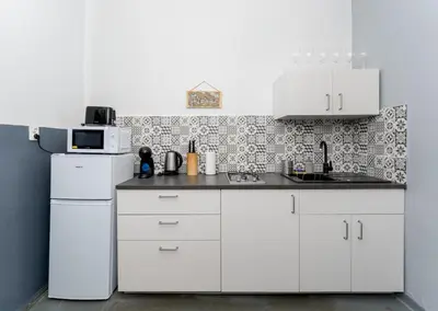 a kitchen with white cabinets and a microwave at Urzędnicza Homely Apartment by BookingHost in Kraków