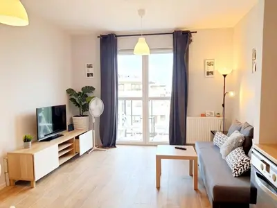 a living room with a couch and a tv at Modern studio on Wrocławska with balcony in Kraków