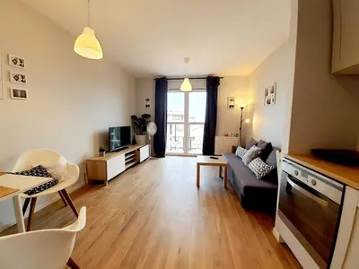 a living room with a couch and a table at Modern studio on Wrocławska with balcony in Kraków