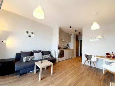 a living room with a couch and a table at Modern studio on Wrocławska with balcony in Kraków