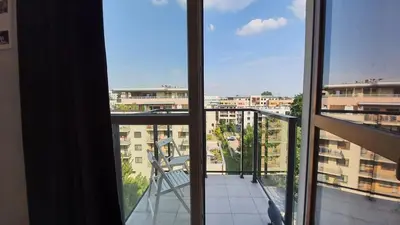a balcony with a chair and a view of a building at Modern studio on Wrocławska with balcony in Kraków