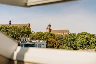 a view from a window of a building with trees at The Krakow Palace near Wawel Castle by BQQK in Kraków