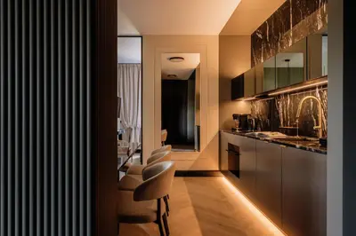 a kitchen with a bar with stools in it at The Krakow Palace near Wawel Castle by BQQK in Kraków