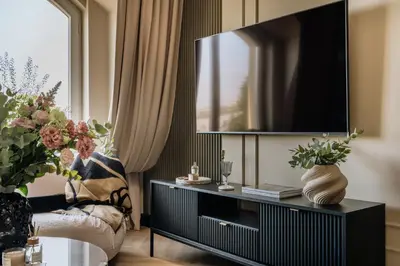 a living room with a tv and a couch at The Krakow Palace near Wawel Castle by BQQK in Kraków