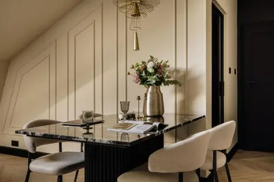 a dining room table with chairs and a vase of flowers at The Krakow Palace near Wawel Castle by BQQK in Kraków