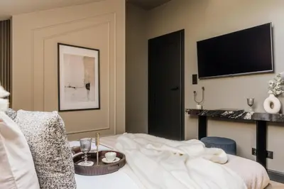 a hotel room with a bed and a tv at The Krakow Palace near Wawel Castle by BQQK in Kraków