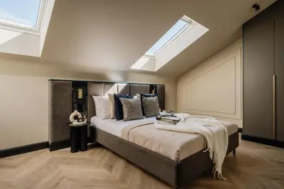a bedroom with a large bed with a skylight at The Krakow Palace near Wawel Castle by BQQK in Kraków