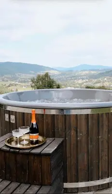 a bottle of wine on a table in front of a tub at Vidok House