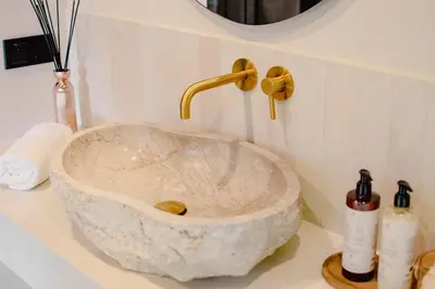 a marble sink with a faucet on a counter at Vidok House