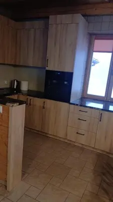 a kitchen with wooden cabinets and a window at Leśna Przystań in Sidzina