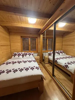 two beds in a room with wooden walls at Leśna Przystań in Sidzina