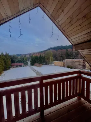 a view from the balcony of a cabin with a snow covered yard at Leśna Przystań in Sidzina