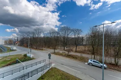 a car is driving down a road with a street light at Czerwone Maki Deluxe Apartment by BookingHost in Kraków