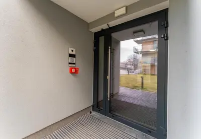 an entrance to a building with a glass door at Czerwone Maki Deluxe Apartment by BookingHost in Kraków