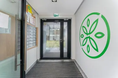 a hallway with a door with a painting on the wall at Czerwone Maki Deluxe Apartment by BookingHost in Kraków