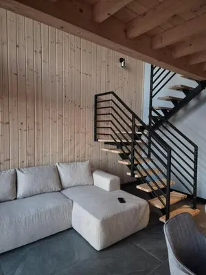 a living room with a couch and a staircase at Stodoła na Hamajdówce in Zubrzyca Górna