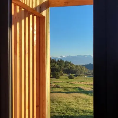 a window with a view of a field and mountains at Stodoła na Hamajdówce in Zubrzyca Górna