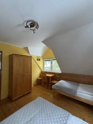 a bedroom with a bed and a table and a window at Ośrodek Nad Potokiem in Poręba Wielka