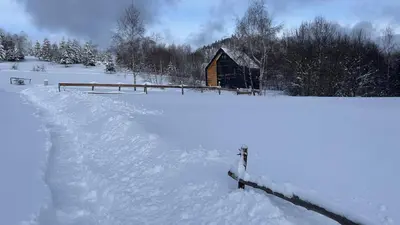 a barn in a field covered in snow at MC Na Leśnej Polanie in Szczawa