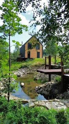 a building in the middle of a field with a pond at MC Na Leśnej Polanie in Szczawa