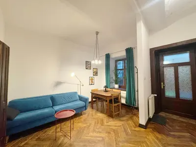 a living room with a blue couch and a table at Tawerna Krakowska in Kraków