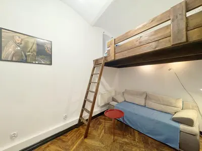 a bedroom with a bunk bed and a ladder at Tawerna Krakowska in Kraków