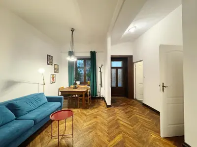 a living room with a blue couch and a table at Tawerna Krakowska in Kraków