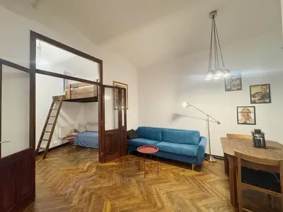 a living room with a blue couch and a bunk bed at Tawerna Krakowska in Kraków
