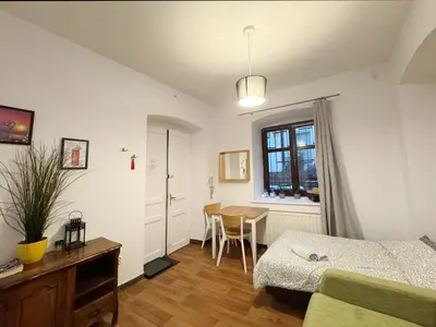 a bedroom with a bed and a table and a window at Asnyka comfy in Kraków