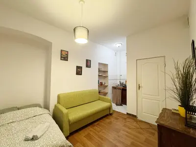 a living room with a green chair and a bedroom at Asnyka comfy in Kraków