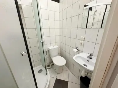a white bathroom with a toilet and a sink at Asnyka comfy in Kraków