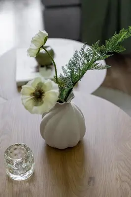 a white vase with flowers in it on a table at Lubicz Boutique Apartment - Old Town Area in Kraków