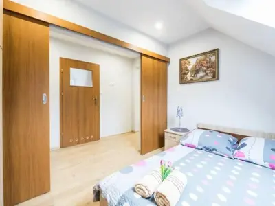 a bedroom with a large bed and a wooden floor at Pod Stokiem in Lubomierz