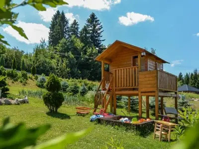 a tree house in the middle of a field at Pod Stokiem in Lubomierz