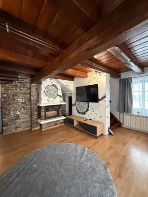a large living room with a stone wall and a tv at Domek Ostoja Zator Graboszyce in Graboszyce