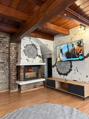 a living room with a fireplace and a tv at Domek Ostoja Zator Graboszyce in Graboszyce